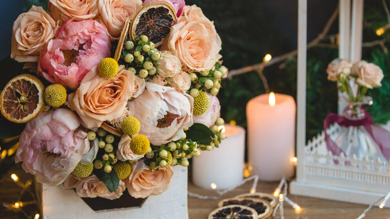 Bouquet of holly berries, peonies and dry lemon slices. 